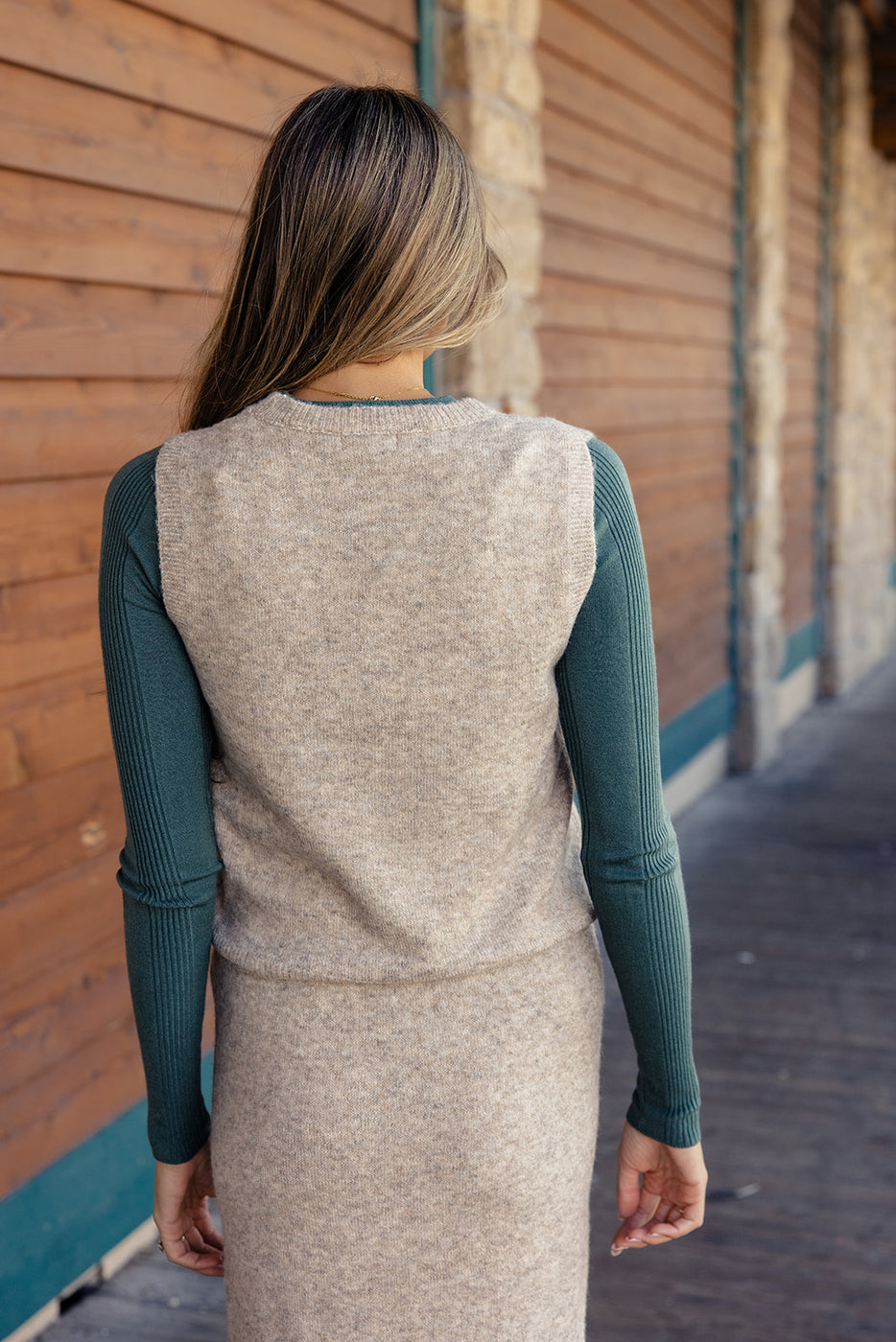 a woman wearing a sweater and a sweater vest