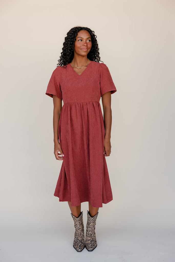 Woman wearing a red dress with a plain background