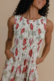Woman wearing a floral dress with red flowers on a beige background
