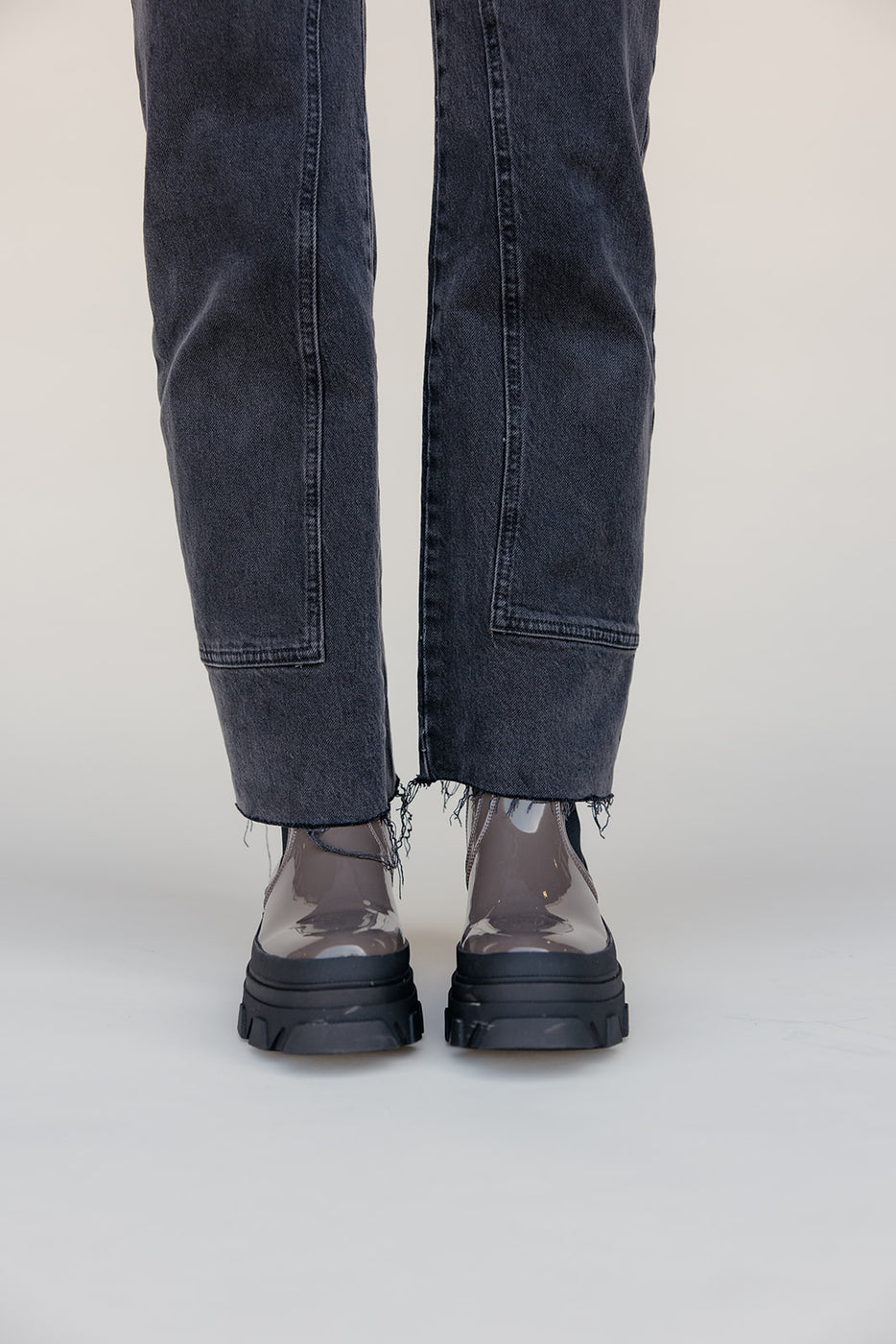 Person wearing black jeans and transparent shoes on a white background
