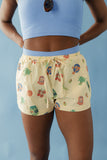 Person wearing a blue crop top and patterned shorts against a light blue background