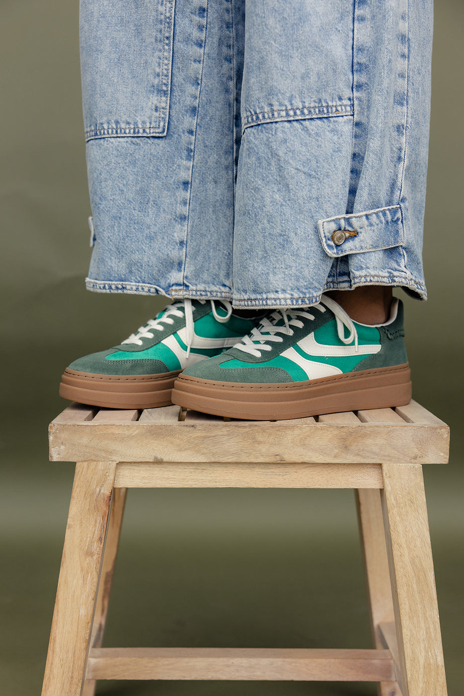 a person's legs and shoes on a stool