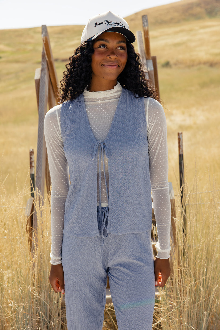 a woman wearing a blue vest and pants