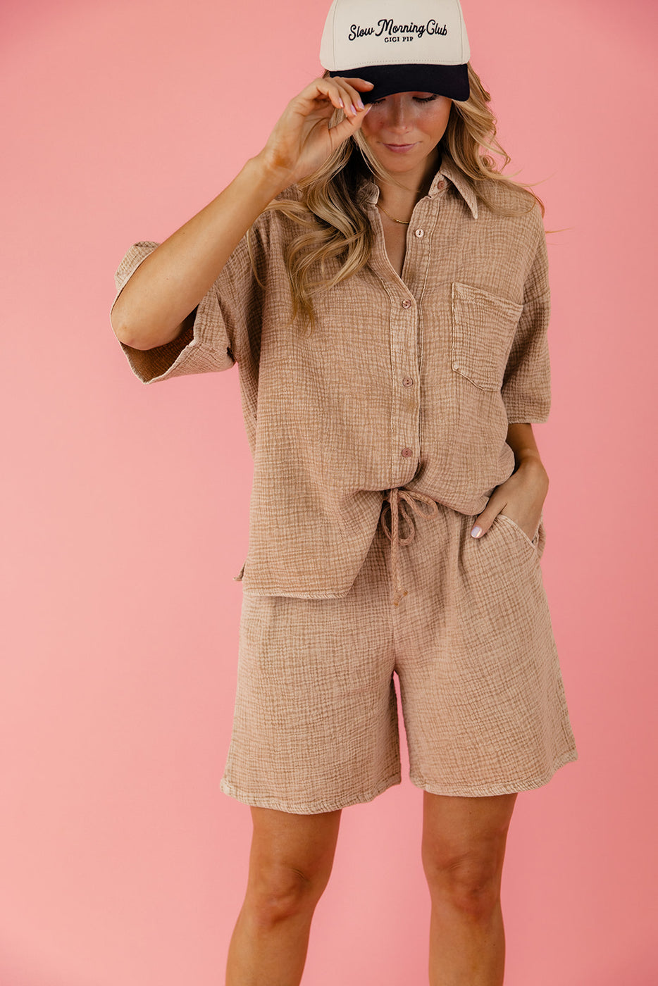 a woman wearing a brown shirt and shorts