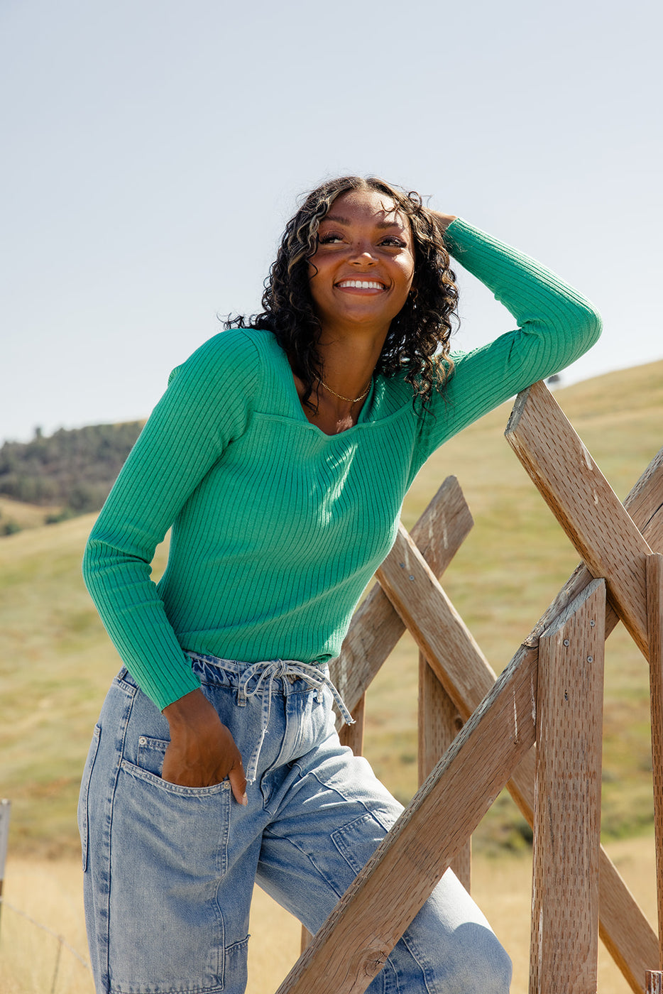 a woman leaning on a fence