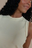 Woman wearing a light green and white striped sleeveless top with a neutral background