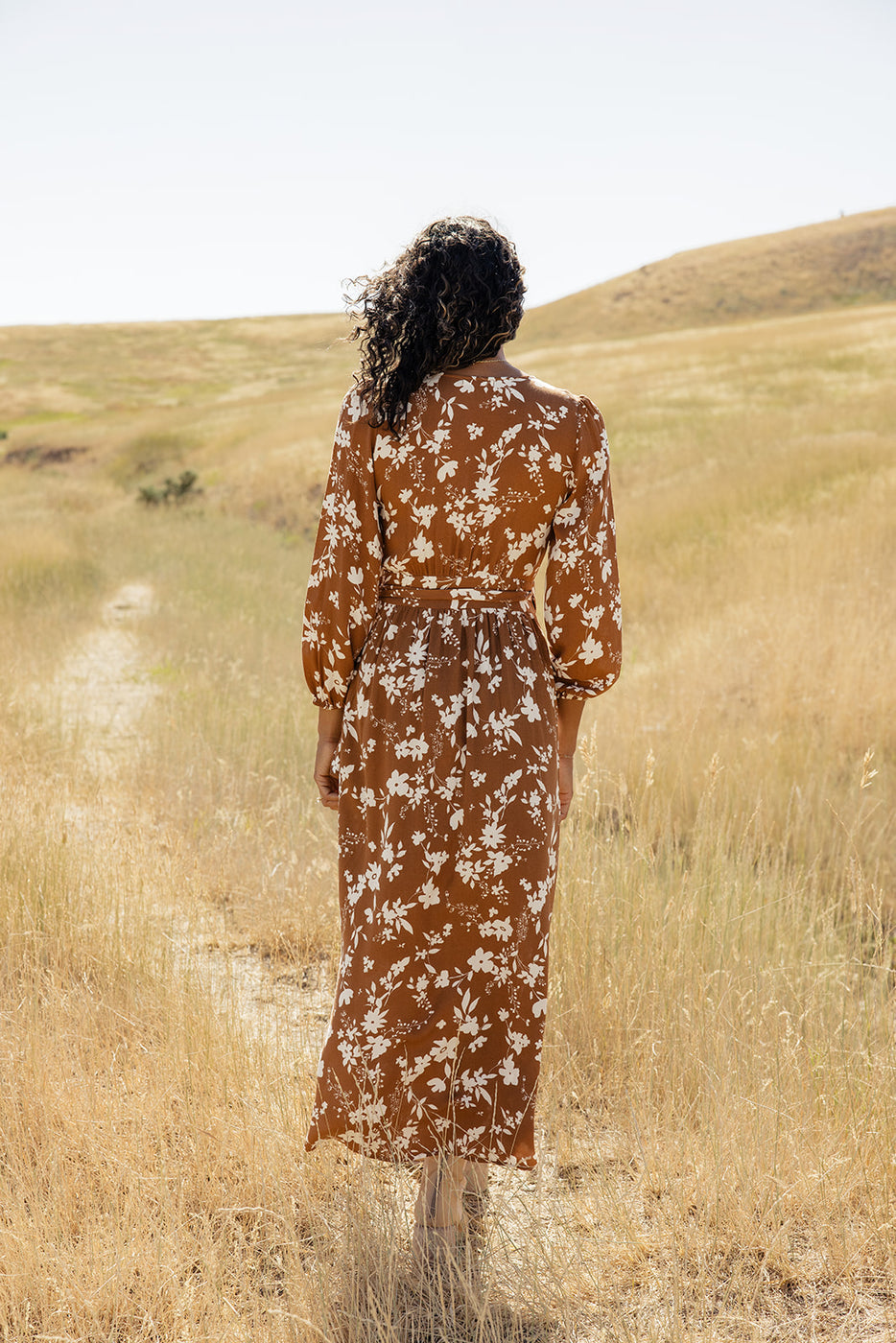 a woman in a long dress standing in a field