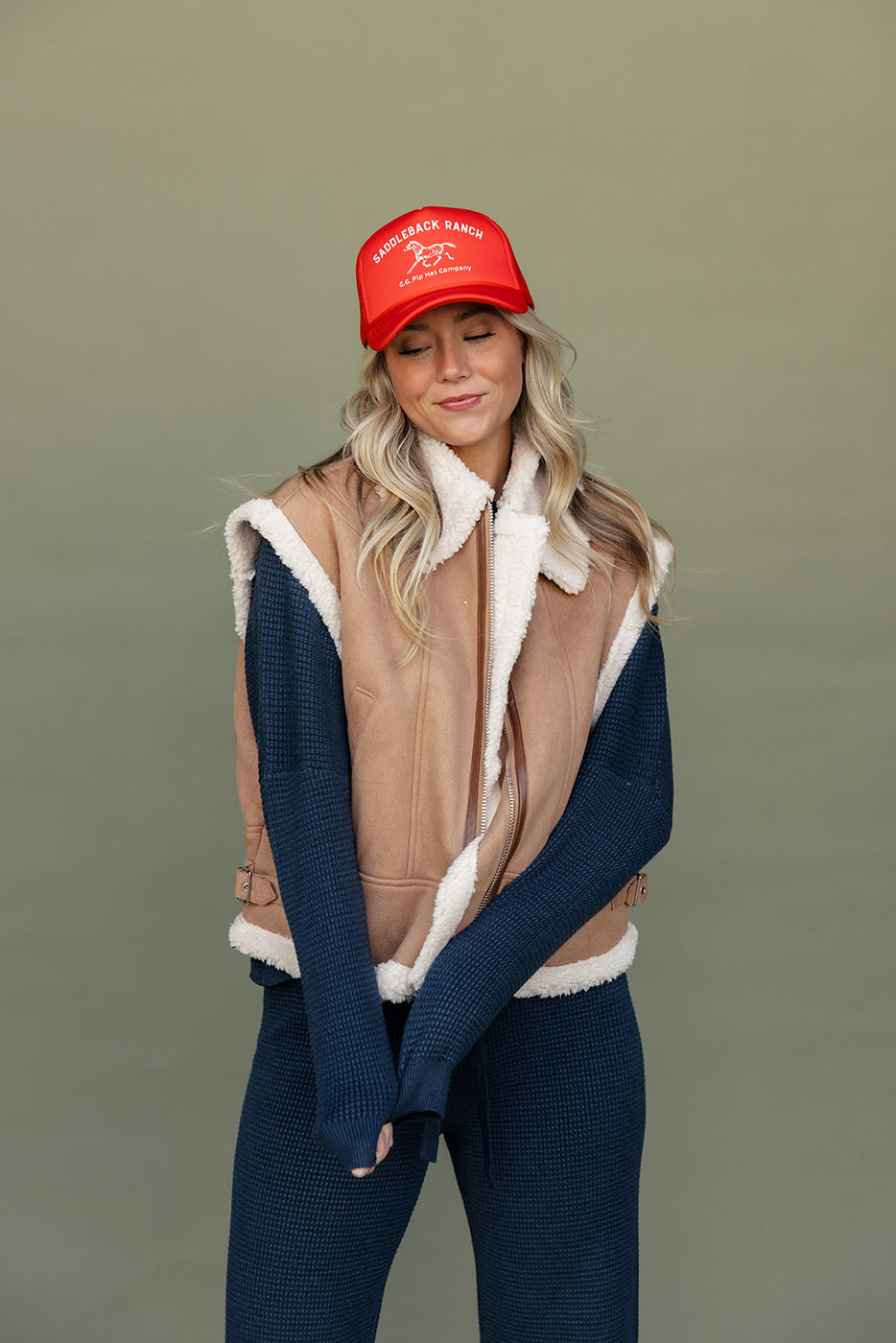 a woman wearing a red hat and vest