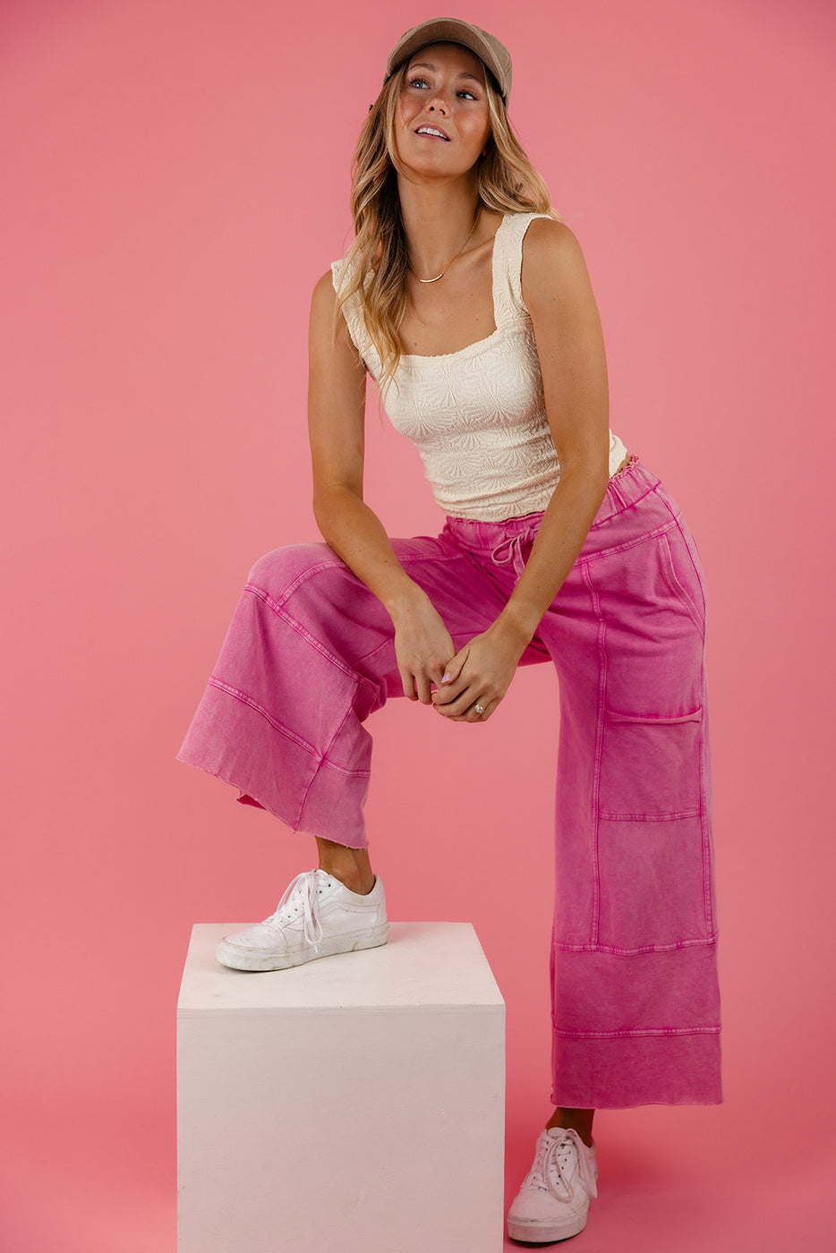 a woman in pink pants and a white tank top
