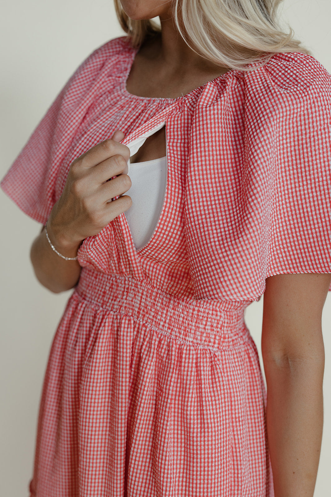 Red and white checkered dress worn by a person against a neutral background