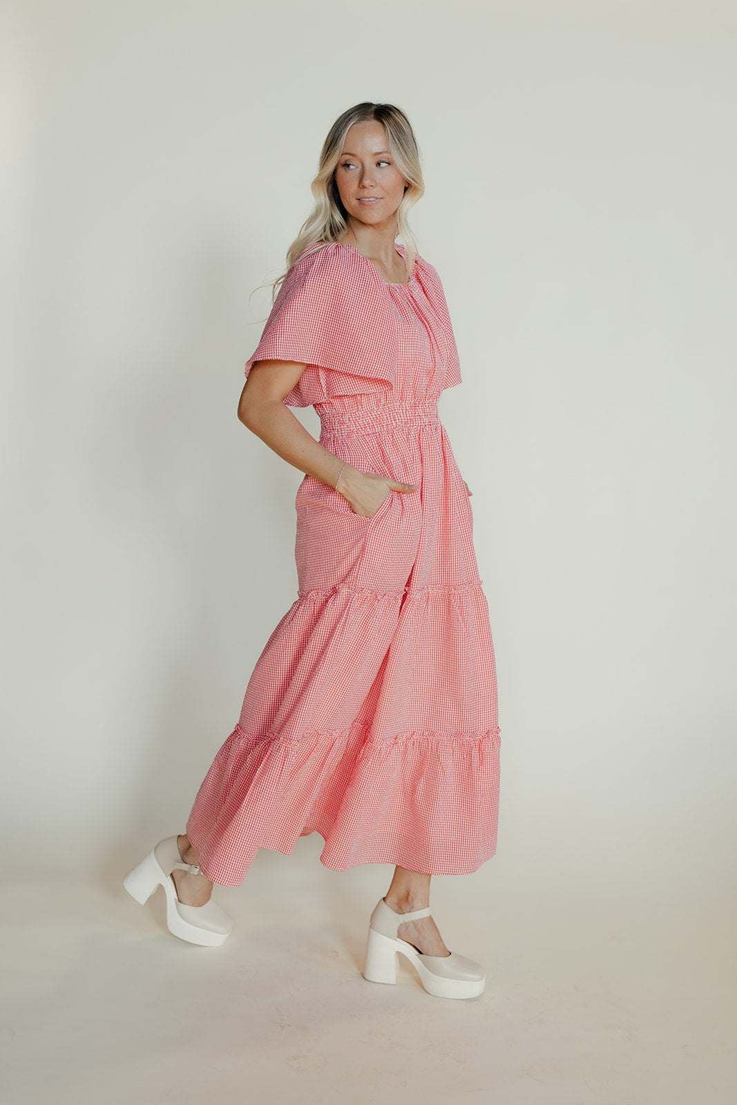 Woman wearing a pink dress with a plain background