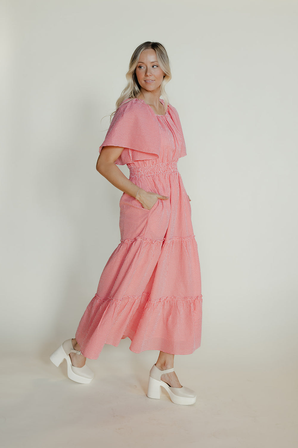 Woman wearing a pink dress with a plain background