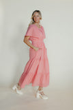Woman wearing a pink dress with a plain background