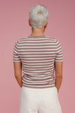 Woman wearing a striped tee shirt against a pink background
