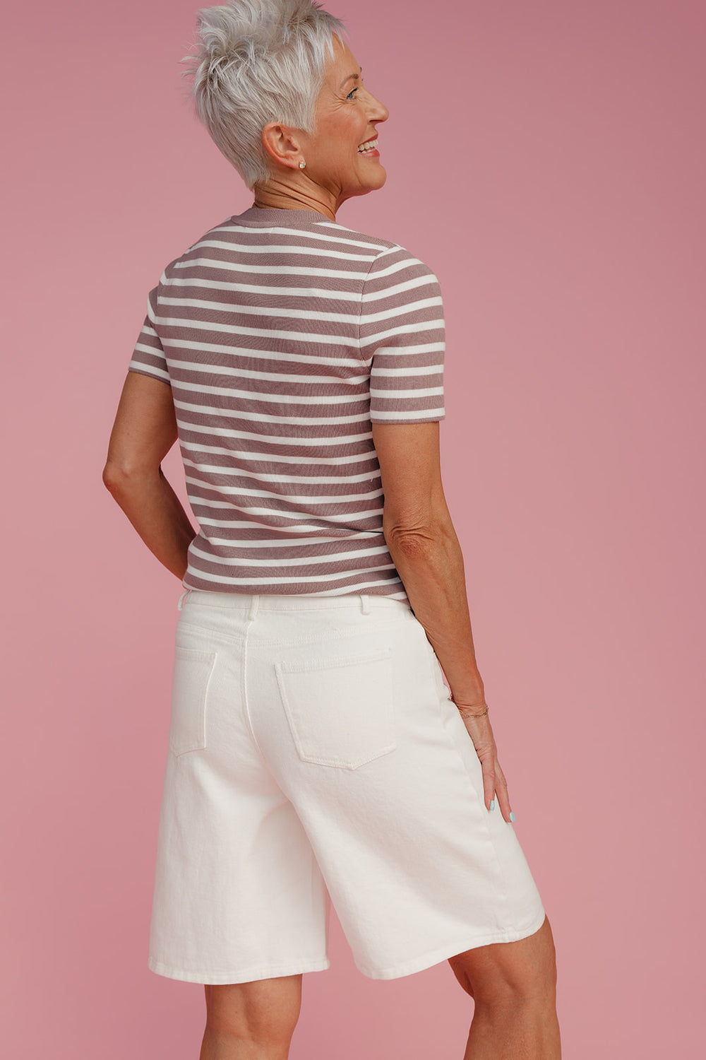Woman wearing long white shorts and a striped t-shirt