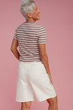 Woman wearing long white shorts and a striped t-shirt