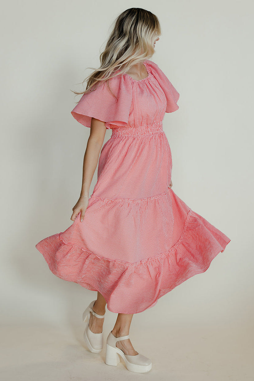 Woman wearing a pink dress against a plain background