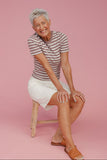 Woman against a pink background wearing a summer outfit