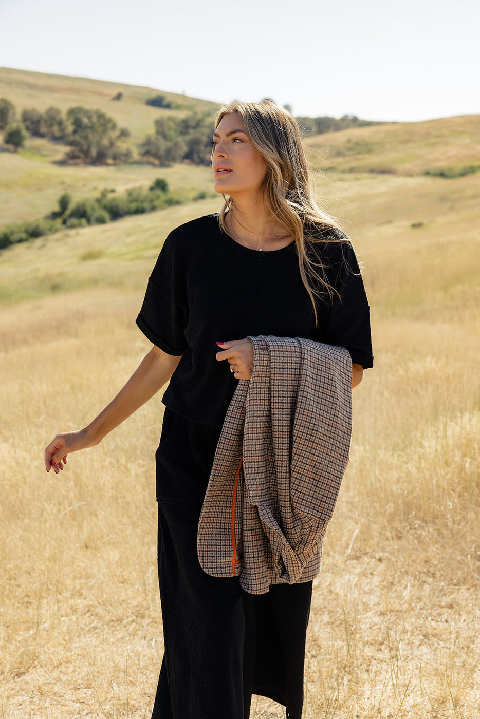 a woman in black clothes in a field