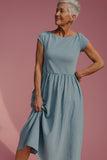 Woman wearing a blue dress against a pink background