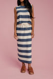 Woman wearing a blue and white striped dress on a pink background