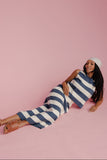 Woman wearing a blue and white striped set on a pink background