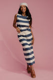 Woman wearing a blue and white striped dress on a pink background