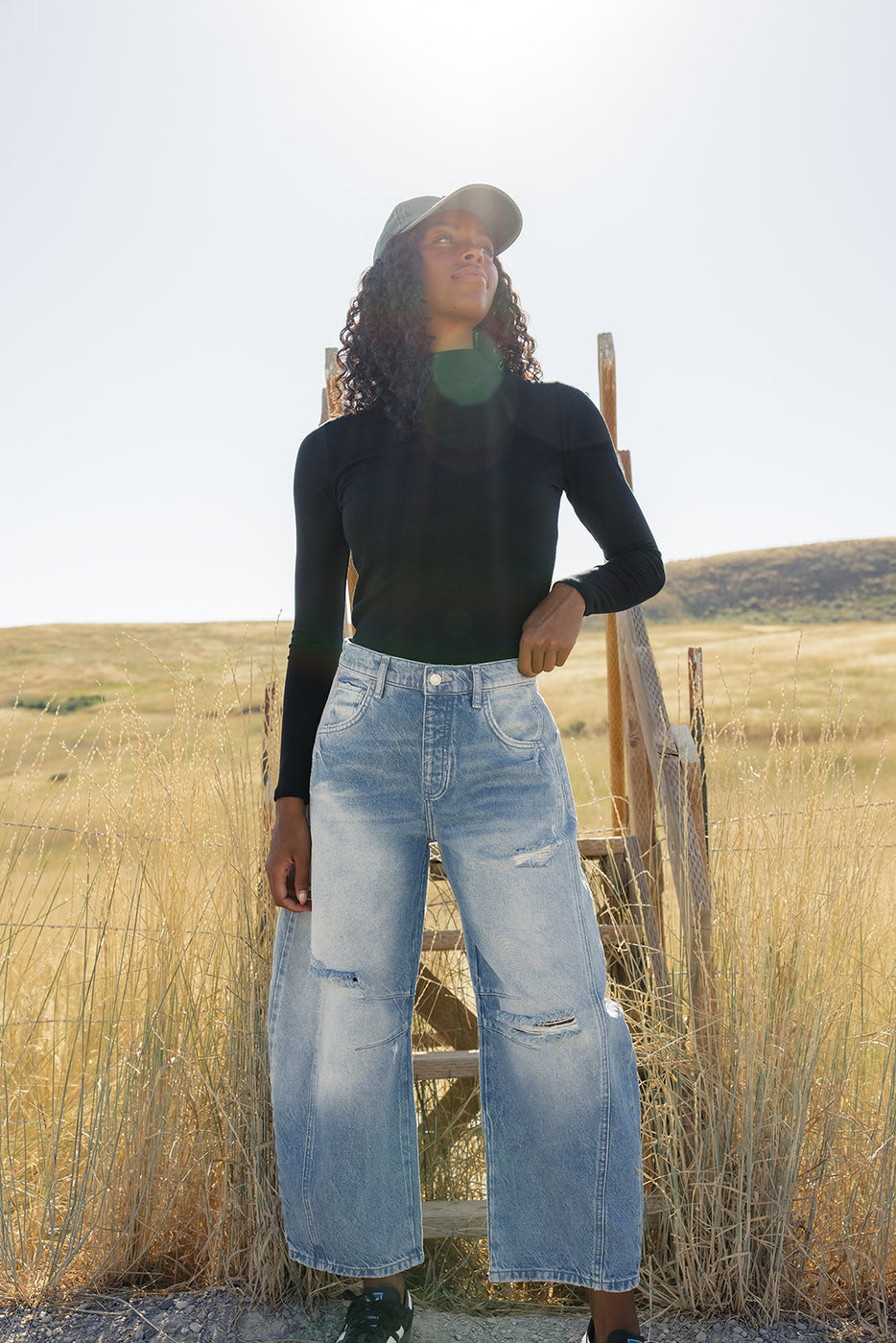 a woman standing on a ladder in a field