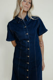 Woman wearing a denim dress against a plain background