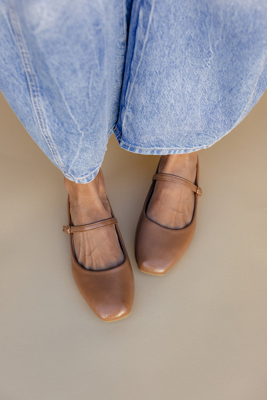 a person's feet wearing brown shoes