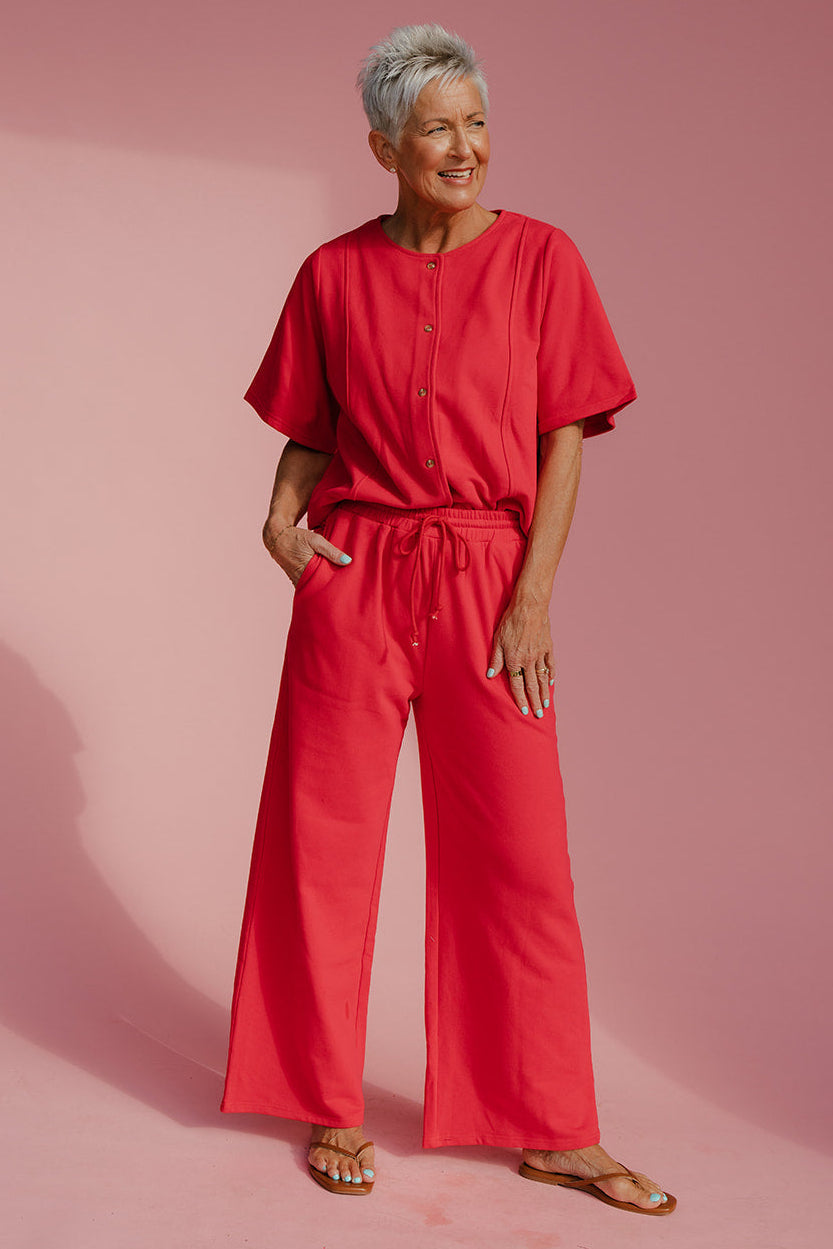 Woman wearing a red outfit on a pink background