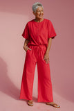 Woman wearing a red outfit on a pink background