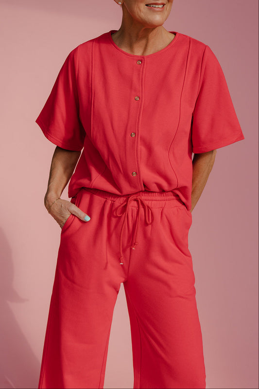 Person wearing a red outfit against a pink background