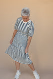 Woman wearing a black and white striped dress on a beige background