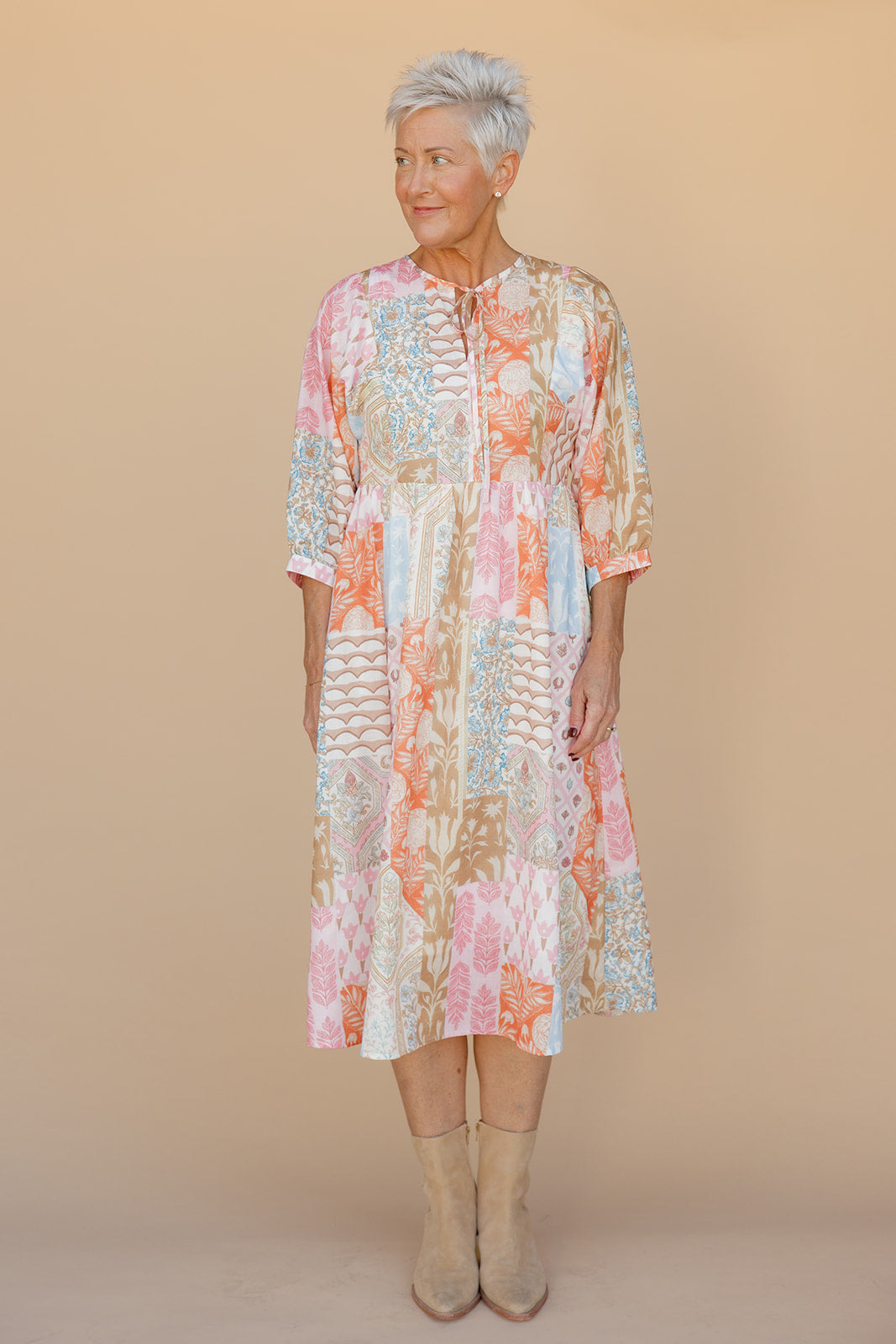 Woman wearing a floral dress against a beige background