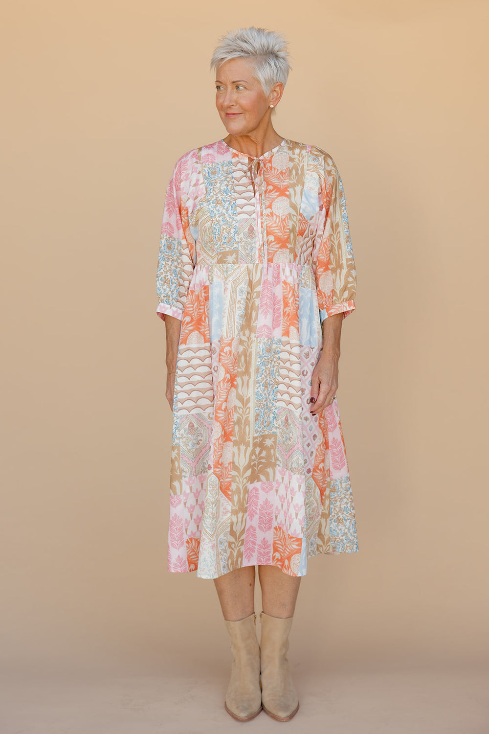Woman wearing a floral dress against a beige background