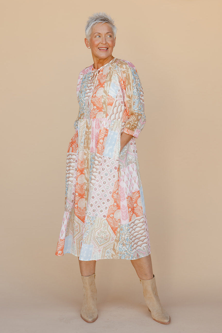 Woman wearing a floral dress against a beige background