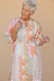 Woman wearing a patterned dress against a beige background