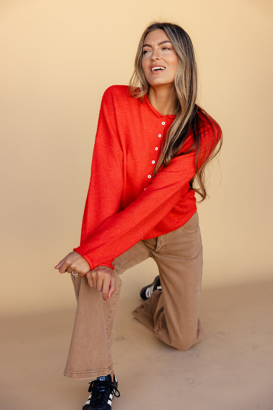 a woman in red shirt and brown pants