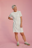 Woman wearing a striped dress on a pink background