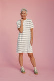 Woman wearing a striped dress against a pink background