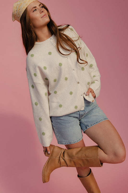 Woman wearing a polka dot sweater, denim shorts, and brown boots on a pink background