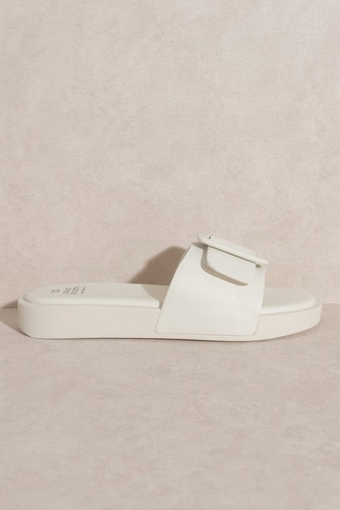 a white sandal with a buckle