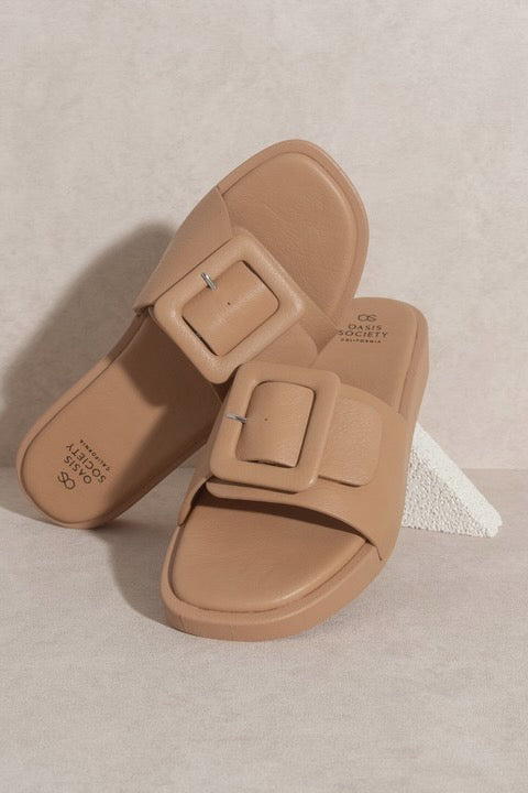 a pair of tan sandals with buckles