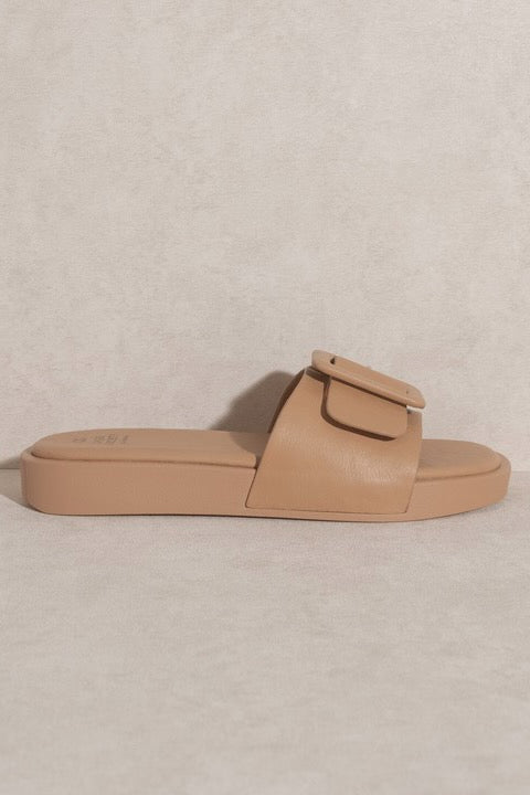 a tan sandal with a buckle
