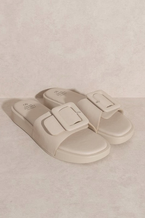a pair of white sandals with buckles
