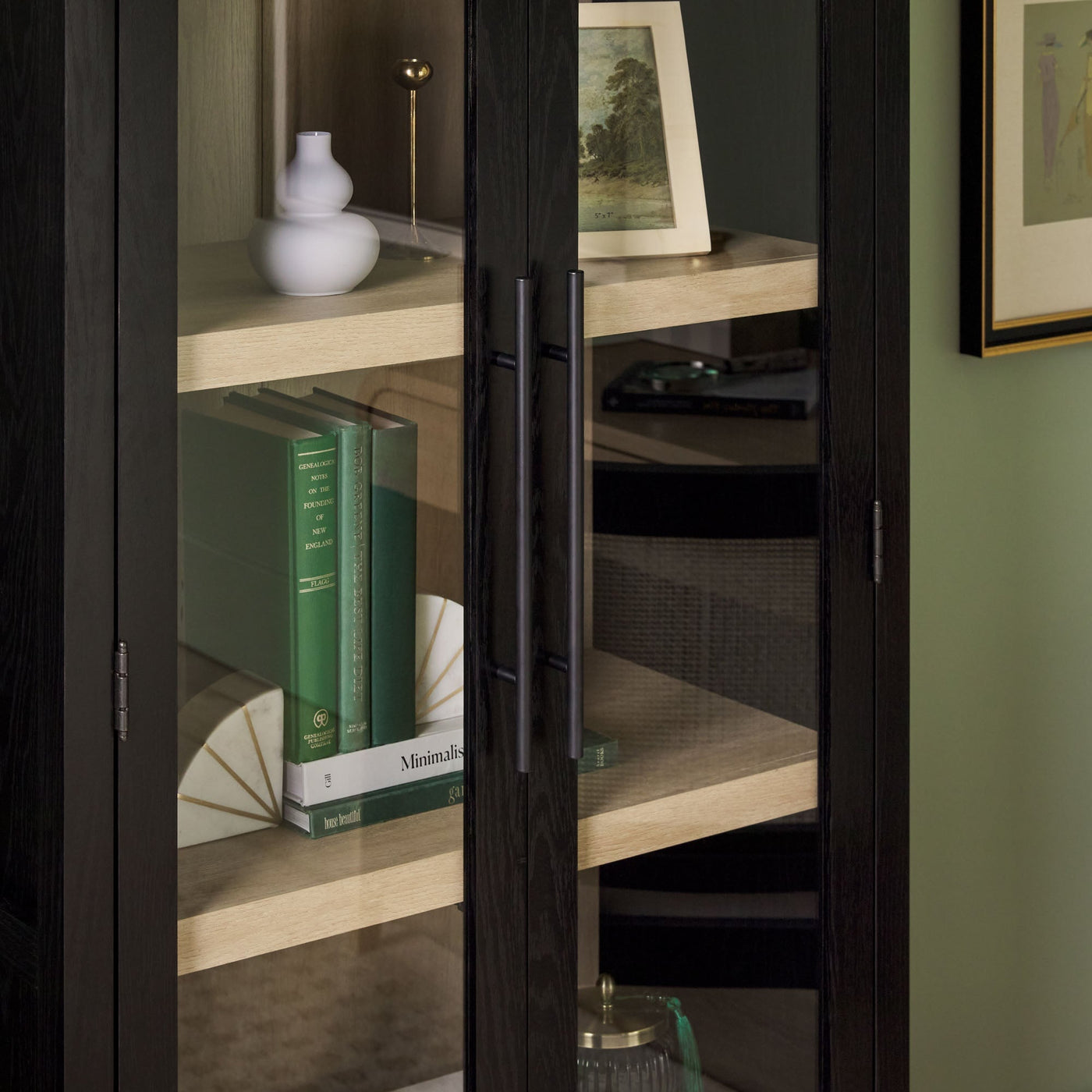 a glass cabinet with books and a picture on it