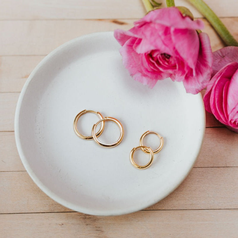 a plate with gold earrings and pink flowers