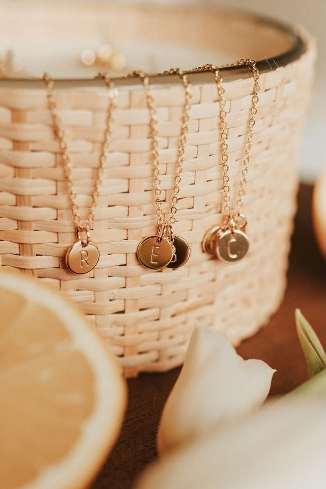 a group of gold necklaces with letters on them