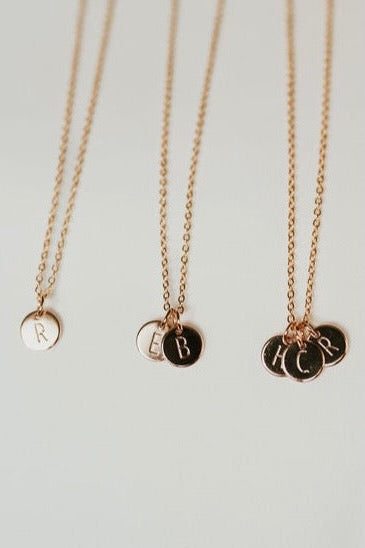 a group of gold necklaces with letters